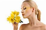 profile shot of cute blond girl looking at some yellow flowers. wellness concept