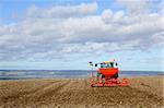 tractor at work sowing spring barley on a hill in the yorkshire wolds england in march