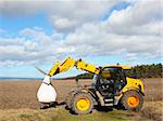 a bright yellow farm loader on the yorkshire wolds england