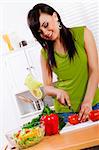 Stock image of woman in kitchen preparing a fresh vegetable salad