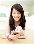 Delighted woman listening music lying on the floor at home