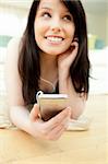 Charming woman listening music lying on the floor at home