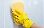 Close-up of a woman cleaning a bathroom with a sponge