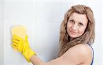 Young woman cleaning a bathroom with a sponge