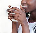 Radiant woman drinking a coffee against a white background