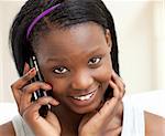 Smiling woman on phone sitting on a sofa in the living-room