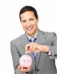 Self-assured businessman saving money in a piggy-bank against a white background