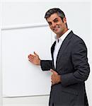 Self-assured male executive pointing at a board at a presentation