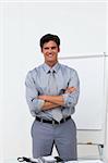 Charming businessman with folded arms in front of a board at a presentation