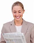 Confident businesswoman reading a newspaper against a white background