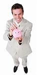 Cheerful businessman saving money in a piggybank against a white background