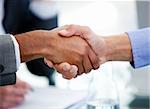 Close-up of business partners shaking hands in a meeting
