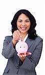 Cheerful businesswoman saving money in a piggybank isolated on a white background
