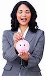 Positive businesswoman saving money in a piggybank against a white background