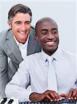 Two cheerful businessman working at a computer in the office