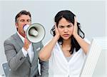 Competitive businessman shouting through a megaphone  in the office