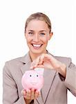 Assertive businesswoman saving money in a piggybank isolated on a white background