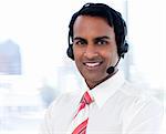 Portrait of a smiling businessman with headsets on in a call centre