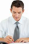 Portrait of a smiling businessman writing at his desk