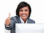 Cheerful businesswoman with a thumb up working at a computer in the office