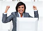Confident businesswoman punching the air in celebration in the office