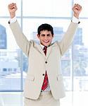 Cheerful businessman punching the air in celebration in the office