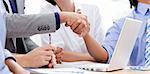 Close-up of business partners shaking hands in a meeting