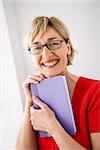 Woman smiling and hugging book.