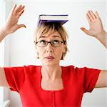 Woman balancing book on head.
