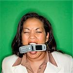 Portrait of African American businesswoman biting cellphone.