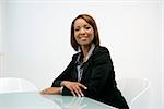 Portrait of smiling African American businesswoman sitting at office desk.