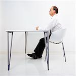 Caucasian middle aged businessman sitting at desk in office.