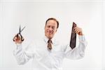 Caucasian middle aged businessman cutting off necktie with scissors.