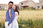 Loving couple, woman hugging her boyfriend in the park