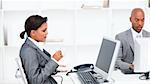 Confident businesswoman drinking a coffe while working at a computer in the office