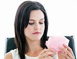 Beautiful businesswoman holding a piggybank  in the office