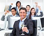 Triumphant manager and his team drinking champagne in the office