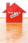 Selling houses concept with a sold sign on the floor indoors