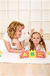 Little girl having fun learning the alphabet with her mother