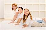 Happy healthy family making gymnastic exercises together - focus on the little girl