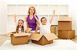 Happy family moving into a new home - with cardboard boxes in an empty room