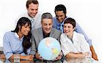 Smiling multi-ethnic business partners holding a globe in the office