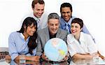A business group showing diversity looking at a terrestrial globe in the office
