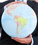 Close-up of a businessman holding a globe in the office