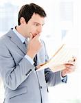 Portrait of a thinking businessman reading a newspaper in the office