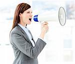 Portrait of an beautiful businesswoman using a megaphone in the office