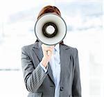 Portrait of an confident businesswoman using a megaphone in the office