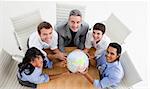 Smiling business people holding a globe in a meeting