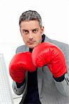 Charismatic businessman with boxing gloves in the office