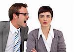 Angry businessman shouting into his colleague's ear in the office
